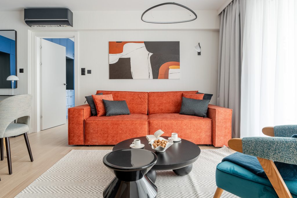 Living room with an orange sofa – modern seaside apartment