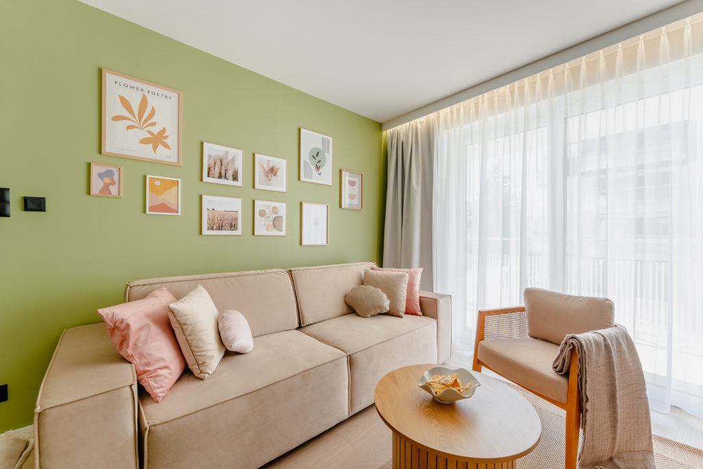 Living room with a green wall and round table – Baltic seaside apartment