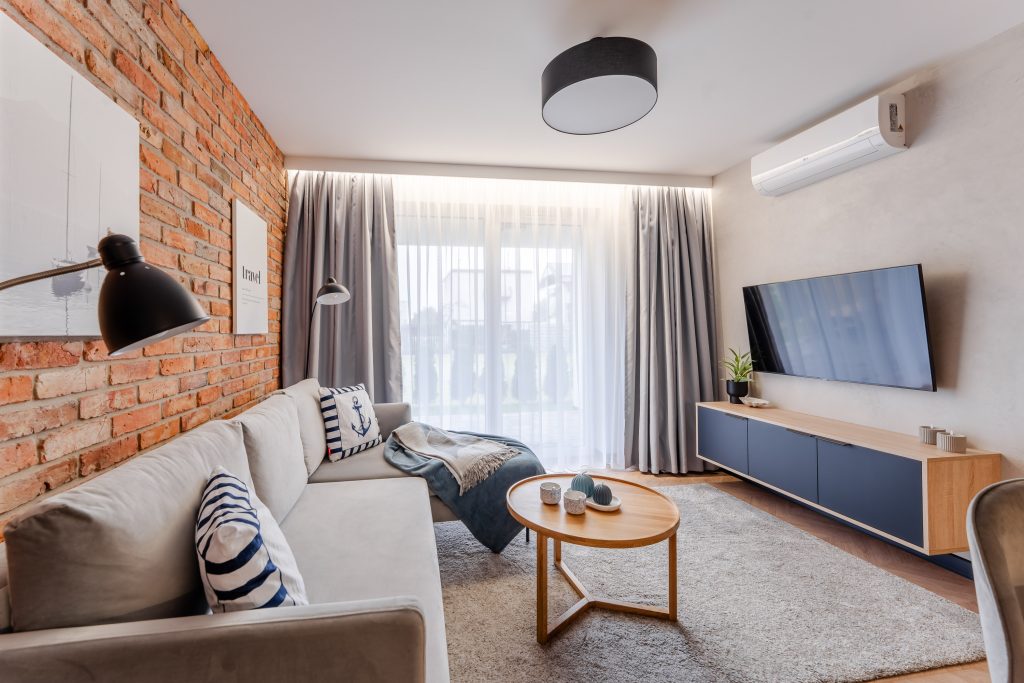 Loft-style living room with a brick wall – Posesja Apartments